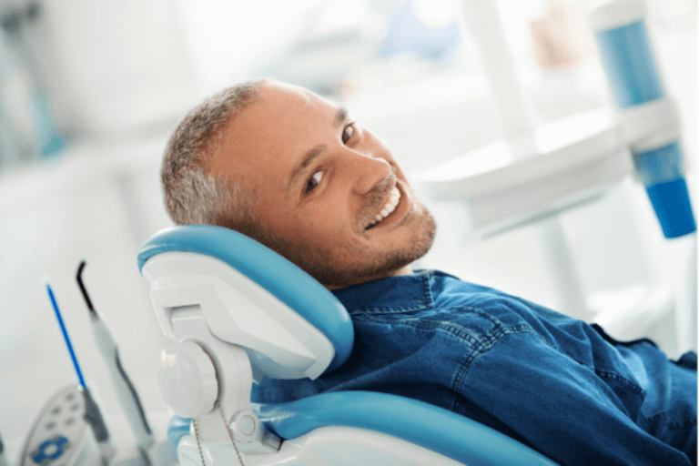 Man in dentist chair after getting dental implant treatment